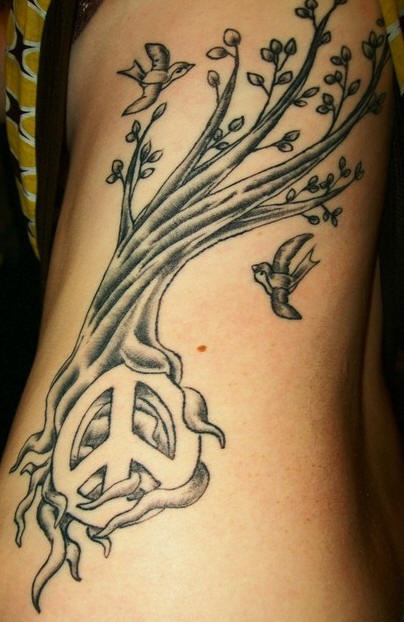 Tatuaje árbol y pa´jaros volando con el signo de la paz