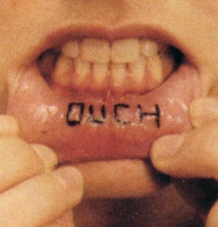 Permanent lip tattoo, ouch, blackaccurate inscription