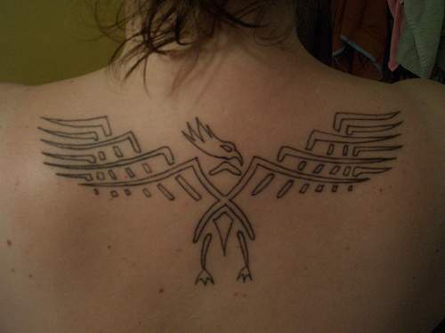 el tatuaje minimalista tribal de la ave fenix en la espalda