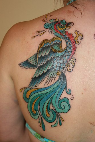 el tatuaje detallado y muy artistico de la ave magica fenix de color azul
