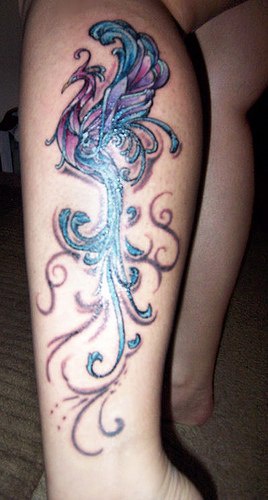 Colourful magic bird tattoo on leg