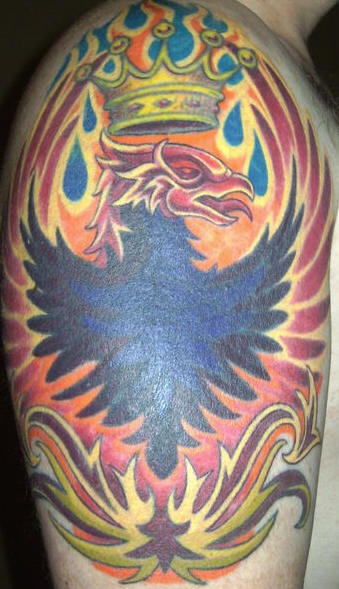 el tatuaje de un ave Fenix con una corona en las llamas de fuego hecho en el hombro