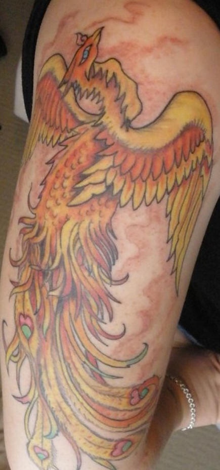 el tatuaje lineado y detallado de la ave fenix de color amarillo y naranja