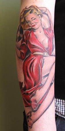 el tatuaje de una chica guera en vestido rojo de estilo pin up hecho en la mano