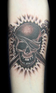 el tatuaje de una calavera malvada con espadas cruzadas en tinta negra