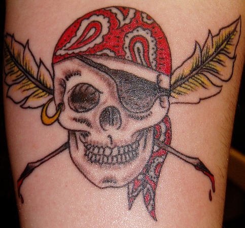 el tatuaje de la calavera pirata  con dos plumas  cruzadas hecho en color