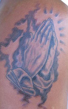 Praying hands and shining tattoo