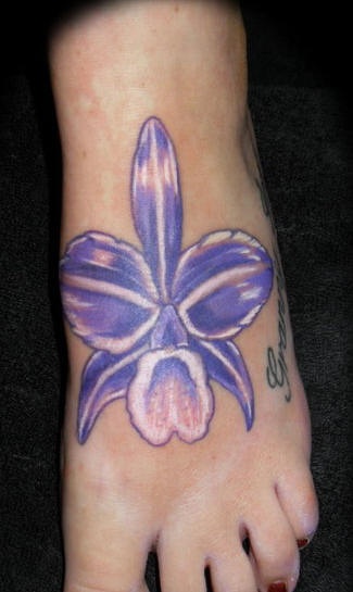 el tatuaje de una flor de color azul con morado y blanco hecho en el pie