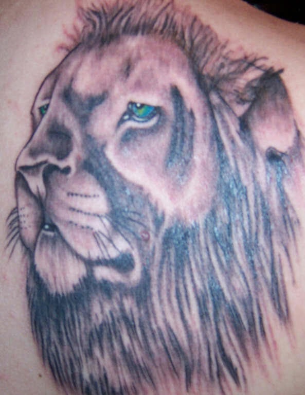 El tatuaje de la cabeza de un leon triste con ojos azules
