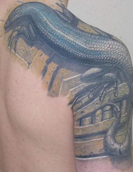 El tatuaje realista y detallado de una lagartija en el hombro