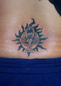 Sun and ankh tattoo on lower back