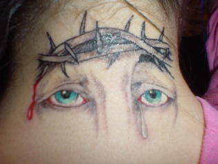 el tatuaje de los ojos de jesucristo con lagrimas hecho en la nuca