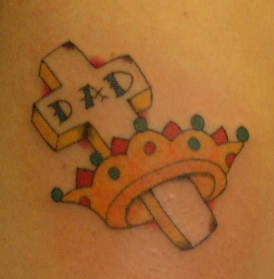 el tatuaje conmemorativo de una cruz con corona de oro yla palabra &quotpapa"