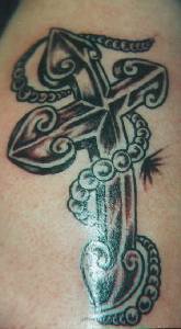 el tatuaje de la cruz con un rosario hecho en color negro