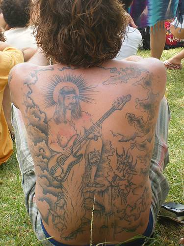el tatuaje grande del jesucristo con una guitarra electirca hecho a toda la espalda