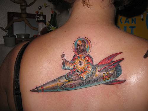 el tatuaje de color con jesucristo en un cohete hecho en la espalda