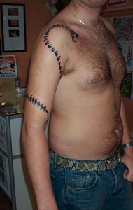 Tatuaje estilo tribal la serpiente negra en el brazo