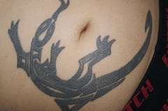 Tatuaje en tinta negra lagartija estilo tribal