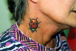 Pequeña mariquita tatuaje en el cuello