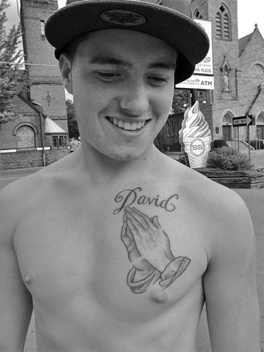 Praying hands and name tattoo