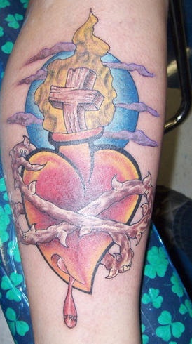 Cross in flame on heart in thorns coloured tattoo
