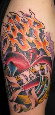 el tatuaje conmemorativo de un corazon en las llamas de fuego hecho en color