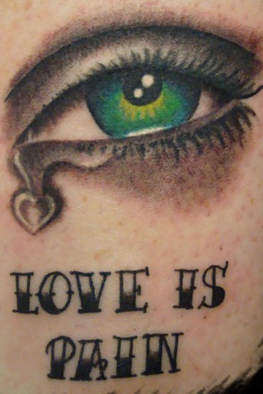 Tatuaje de un ojo realístico con la frase amor es dolor