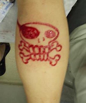 Tatuaje sacrificio en la piella calavera loca con huesos