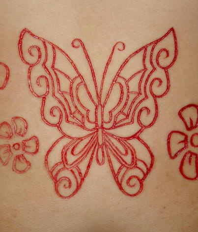 Tatuaje de mariposa con flores sacrificio en la piel