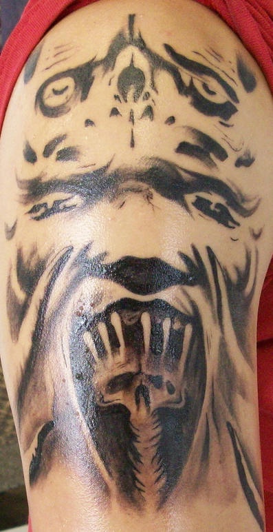 Tatuaggio spaventoso non colorato sul braccio il mostro che urla