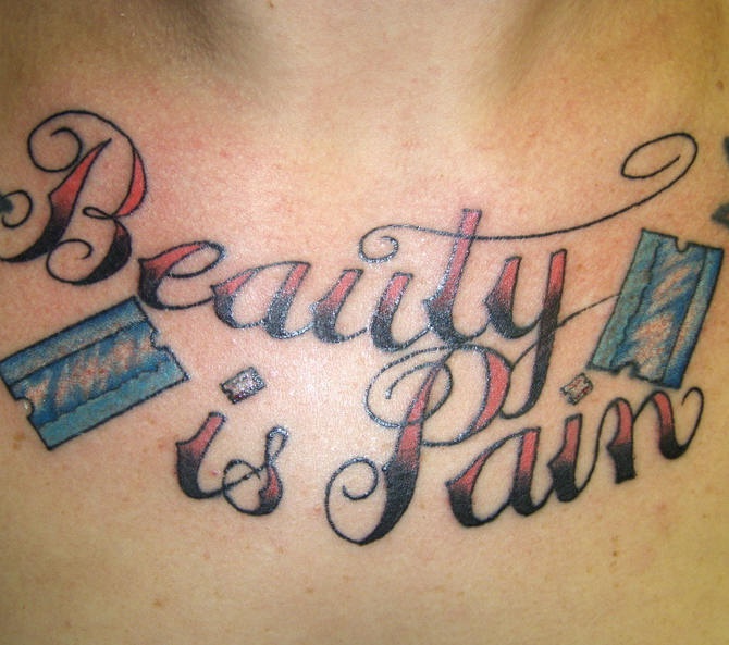 Tatuaggio colorato sul petto &quotbeauty is pain"