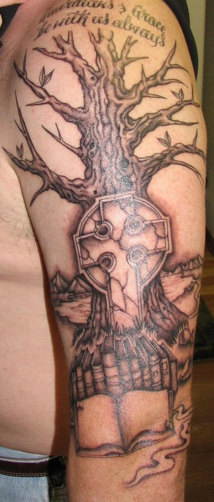 Tatuaje en el hombro con árbol, libros y una inscripción grace will be always