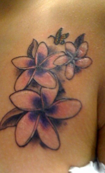 Precioso tatuaje en hombro tres flores rosadas y una mariposa volada