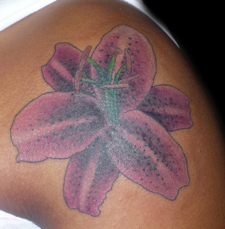 Le tatouage de l"épaule avec une jolie fleur pourpre mystique