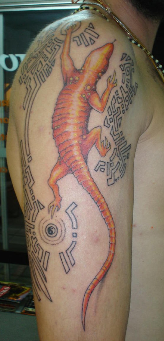 Le tatouage de l"épaule avec un longue lézard orange stylisé