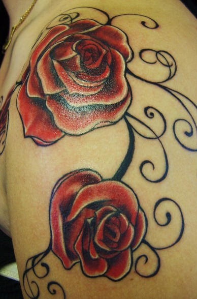 Gran tatuaje en hombro con dos rosas rojas bien decoradas