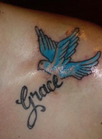 Le tatouage de l"épaule avec un bleu colombe volant et un mot grâce