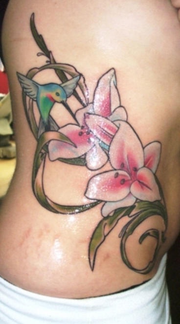 Tatuaje en el costado, colibrí volando cerca de la flor