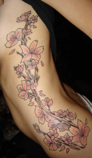 Tatuaggio grande sul fianco il ramoscello di sakura fiorito