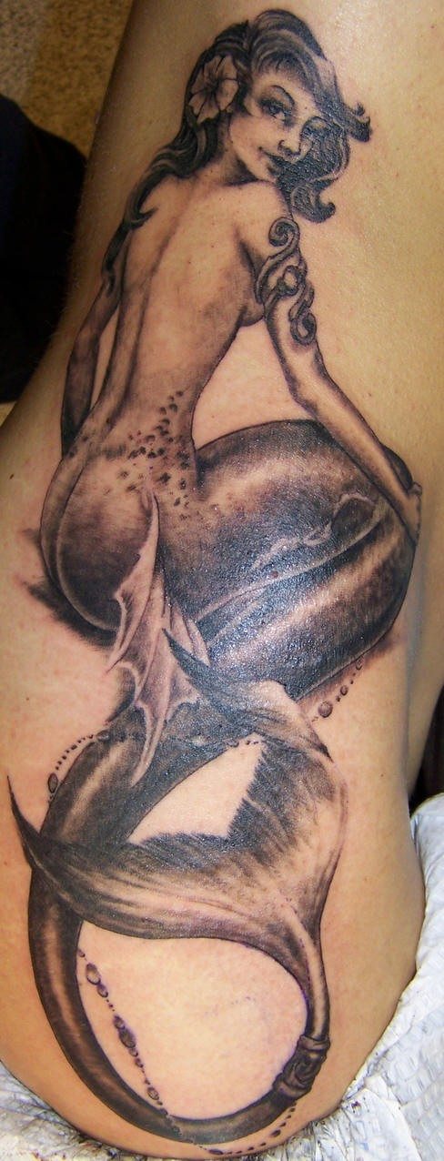 Tatuaje en el costado sirena sentada en la playa en tinta negra
