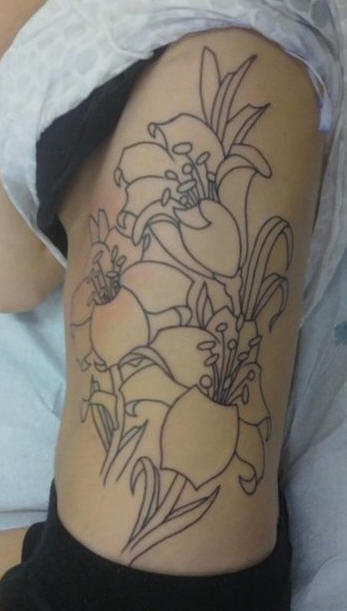 Tatuaje en el costado, tres flores preciosas en tinta negra