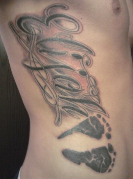Side tattoo, foot tracks, black eliah name