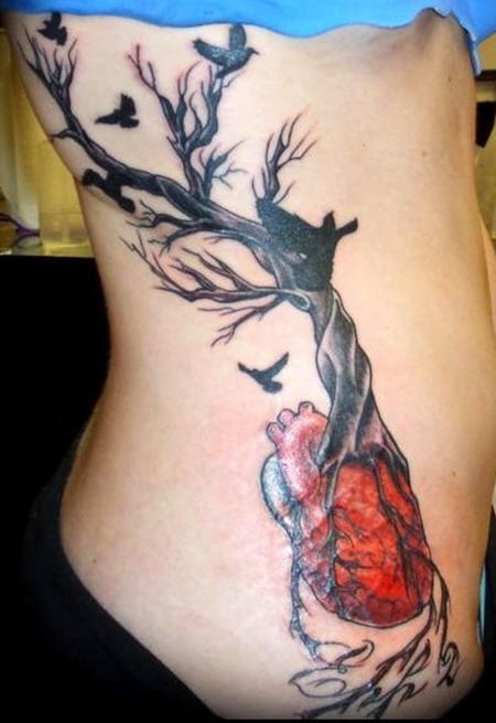 Tatuaggio sul fianco l&quotalbero senza vita con le radici che escono da cuore
