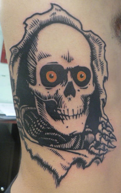 Tatuaje con el logo del patinete esqueleto en la piel cortada