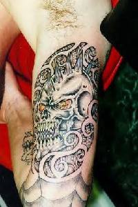 Black demon skull tattoo on arm