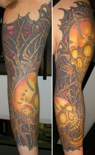 Shoulder tattoo of skulls and trees
