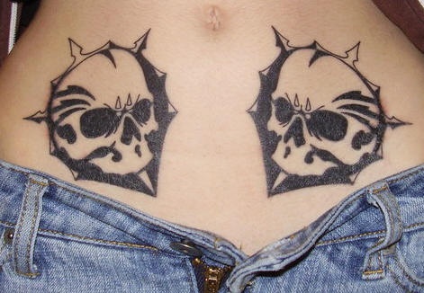 Stomach tattoo, two, black, symmetrical, angry skulls