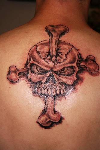 Calavera con cruz hecha de huesos tatuaje en color