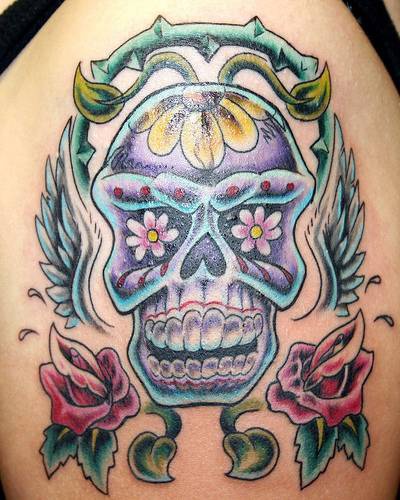 Winged sugar skull with flower tracery tattoo