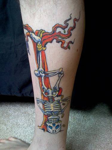 Skelett hängt auf Baum farbiges Tattoo